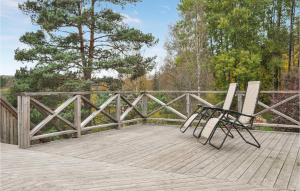 a bench sitting on a wooden deck with a fence at 3 Bedroom Pet Friendly Apartment In Deje in Deje