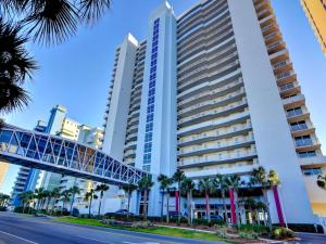 ein hohes Gebäude mit einer Brücke davor in der Unterkunft Majestic Beach Towers II 1902 in Panama City Beach