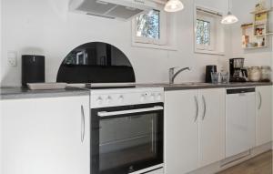 eine weiße Küche mit Herd und Spüle in der Unterkunft 3 Bedroom Awesome Home In Rdby in Rødby