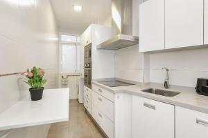 a white kitchen with white cabinets and a sink at Sara Love Downtown in Granada