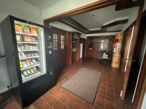 Ein Zimmer mit einem offenen Kühlschrank mit Lebensmitteln in der Unterkunft Landhotel Vessens Hoff in Buchholz in der Nordheide