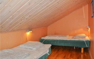 two beds in a room with a wooden ceiling at 6 Bedroom Gorgeous Apartment In Slen in Sälen