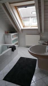 a bathroom with a sink and a tub and a skylight at Ferienwohnung Ruheoase in Bad Kissingen