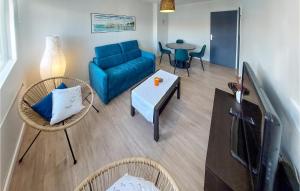 ein Wohnzimmer mit einem blauen Sofa und einem Tisch in der Unterkunft Cozy Apartment In Royan With Wifi in Royan