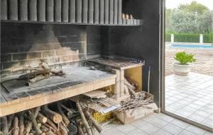 una cocina con parrilla con una pila de madera en Awesome Home In Vilallonga With Kitchen, en Vilallonga (Villalonga)