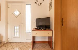 una habitación con TV en un tocador con puerta en Stunning Apartment In Nin With Kitchen, en Nin