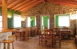 un restaurante con mesas y sillas de madera y paredes verdes en Awesome Home In Vilallonga With Kitchen, en Vilallonga (Villalonga)
