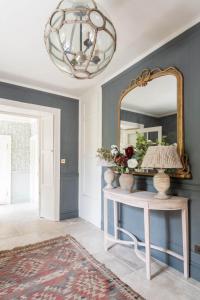 a room with a mirror and a table with a lamp at Tacket Wood House in Kingsbridge