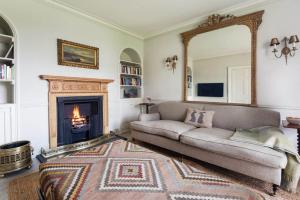 a living room with a couch and a fireplace at Tacket Wood House in Kingsbridge