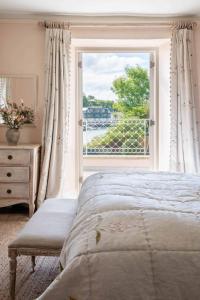 a bedroom with a bed and a large window at Tacket Wood House in Kingsbridge