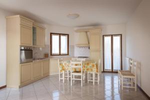 a kitchen with a table and chairs in it at Appartamento al Sole in Colà di Lazise