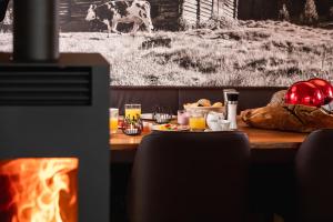 einen Tisch mit Essen und eine Kuh im Hintergrund in der Unterkunft Wildkogel Resorts - DAS Bramberg in Bramberg am Wildkogel