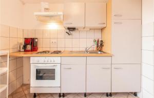 a small kitchen with white cabinets and a sink at Pet Friendly Apartment In Nin With Wi-fi in Nin