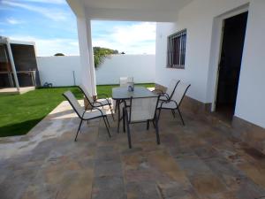 eine Terrasse mit einem Tisch und Stühlen im Hof in der Unterkunft Casa rural Majadales piscina privada alta calidad in Conil de la Frontera