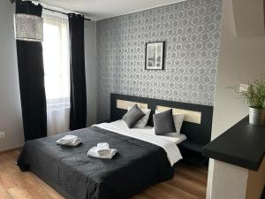 ein Schlafzimmer mit einem Bett mit zwei Handtüchern darauf in der Unterkunft H-Apartamenty Junior in Nowa Sól