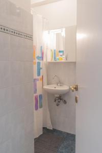 uma casa de banho branca com um lavatório e um espelho em Gtrip Glyfada Getaway Studio - 5045 em Atenas
