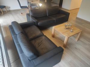 uma sala de estar com um sofá de couro e uma mesa de centro em Ferienwohnung Fynns PeerLe em Bad Harzburg