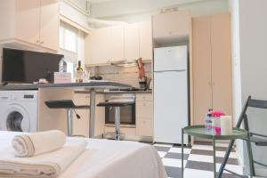 uma cozinha com um frigorífico branco e uma mesa em Gtrip Glyfada Getaway Studio - 5045 em Atenas