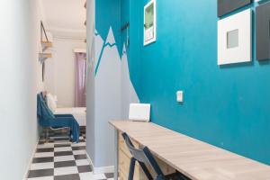 um quarto com uma parede azul e uma mesa com um vestido em Gtrip Glyfada Getaway Studio - 5045 em Atenas