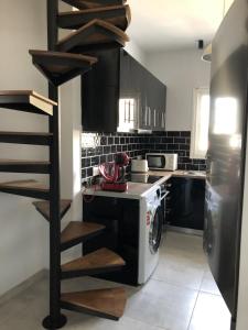 a kitchen with a washer and dryer next to a stove at Gtrip Gazi Duplex Apartment - 33701 in Athens