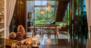 uma sala de jantar com mesa e cadeiras numa casa em Limon Villa Khao Yai by Tolani em Wangkata