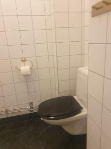 ein Badezimmer mit einem schwarzen WC und einem schwarzen Sitz in der Unterkunft Centrala stan Hel 2 rums Gästsvit in Umeå