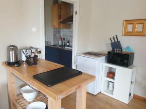 a kitchen with a wooden table with a counter top at Rymlig 2-rumssvit nära Centralstationen - Anna Josefinas Stay in Umeå +15 photos