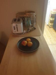 un plato con tres naranjas en una mesa en Centrala stan Hel 2 rums Gästsvit en Umeå