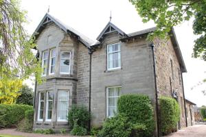 una vecchia casa di mattoni con cespugli di fronte di Brackness House Luxury B&B a Anstruther