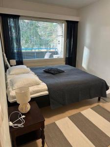 een slaapkamer met een bed, een raam en een tafel bij Welcomly apartment MILA in Kotka