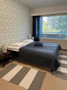 a bedroom with a large bed and a window at Welcomly apartment MILA in Kotka