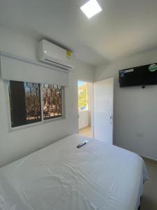 een slaapkamer met een wit bed en een raam bij ANCON HOUSE in Taganga