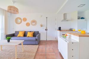 un soggiorno con divano blu e una cucina di Apartamento en Benagalbón con terraza by Alterhome a Torre de Benagalbón