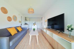 un soggiorno con divano blu e TV a schermo piatto di Apartamento en Benagalbón con terraza by Alterhome a Torre de Benagalbón