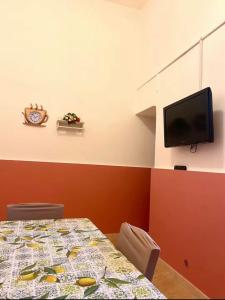 ein Esszimmer mit einem Tisch und einem TV in der Unterkunft House 55 in Catania
