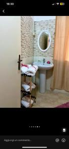 een badkamer met een wastafel en een spiegel bij House 55 in Catania