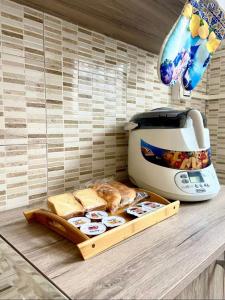 eine Küchentheke mit einem Toaster und einem Schneidebrett mit Brot in der Unterkunft House 55 in Catania