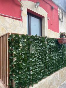 ein Gebäude mit einer grünen Wand und einem Fenster in der Unterkunft House 55 in Catania