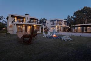 ein Feuer im Hof eines Hauses mit Stühlen und einer Feuerstelle in der Unterkunft Complejo il Pensiero Punta del Diablo in Punta Del Diablo