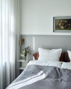 una camera bianca con un letto e una finestra di Hotel Ny Hattenæs a Silkeborg