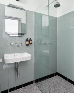 W łazience znajduje się umywalka i przeszklony prysznic. w obiekcie Hotel Ny Hattenæs w mieście Silkeborg
