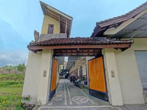 - un bâtiment avec des portes orange et des fauteuils dans la ruelle dans l'établissement OYO 93295 Wisma Aluh Ambak, 