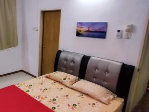 a bedroom with a bed with a leather head board at Pinang Beach Home @ Ferringhi in Batu Ferringhi