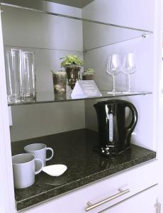 a counter with a coffee maker and glasses on it at Lindekroon Guest House in Polokwane