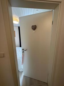 Una puerta blanca con un imán cardíaco. en Unterkunft zur Sternblume, en Bruchweiler-Bärenbach