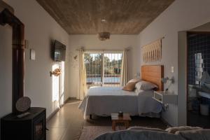 a bedroom with a bed and a large window at Complejo il Pensiero Punta del Diablo in Punta Del Diablo