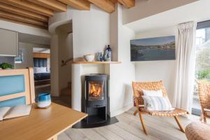 a living room with a fireplace and a table and chair at The Edge in Dartmouth