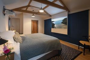a bedroom with a bed and a large painting on the wall at The Printworks in Salcombe