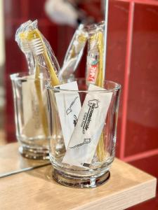 two glasses with toothbrushes in them on a table at Apartamenti DVINSKA in Daugavpils