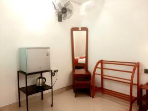 La salle de bains est pourvue d'un miroir, d'un lavabo et d'un ventilateur. dans l'établissement Palitha Homestay, à Sigirîya
